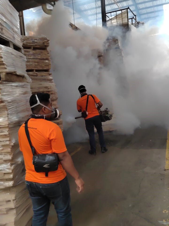 Two technicians fogging a warehouse